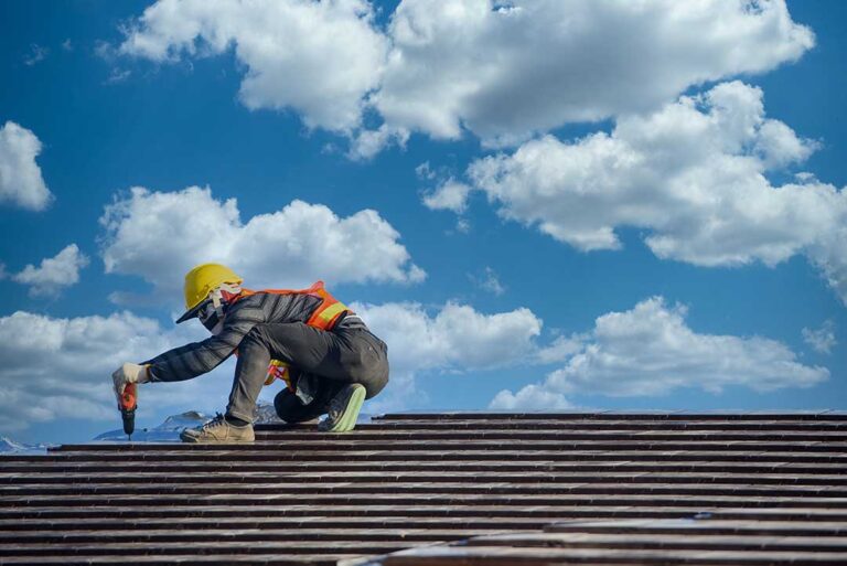 Homeowner compares roofing documents beside a damaged roof while reviewing inspection photos.